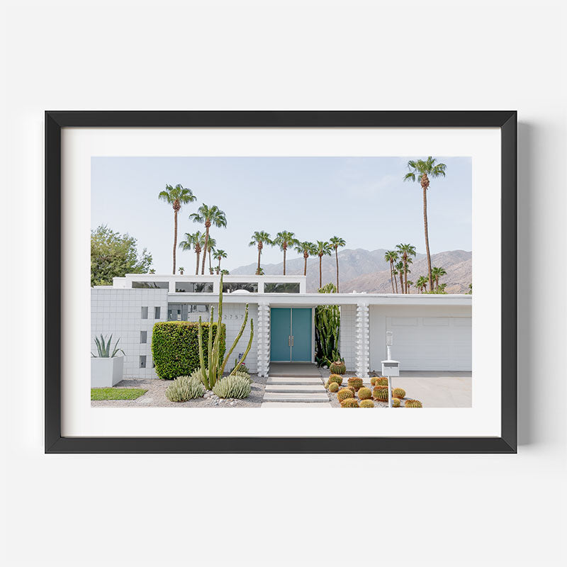 Framed photograph of a modern house with palm trees in the background