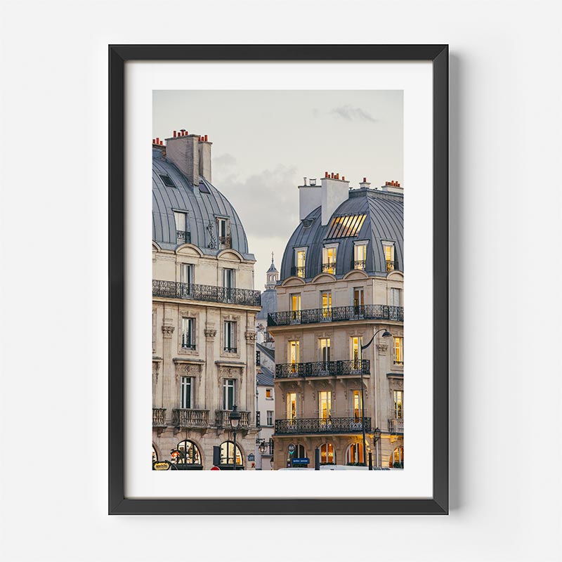 Framed photograph of a city street with buildings on a white wall