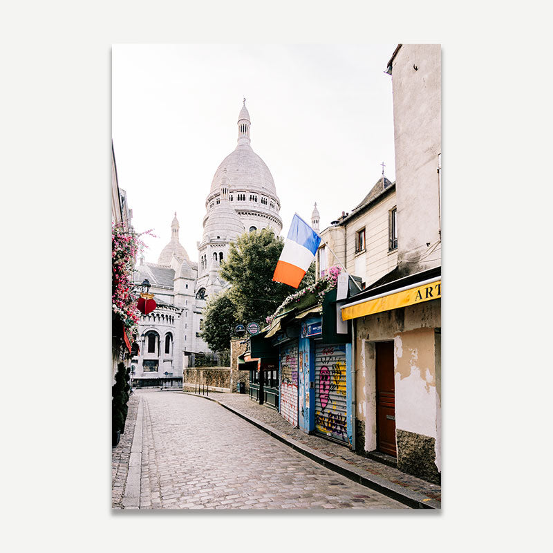 Street scene with a cathedral and French flag in Montmartre, Paris.