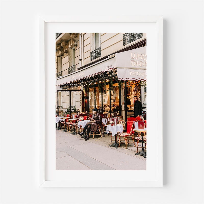 Framed photograph of an outdoor cafe scene with people sitting at tables.