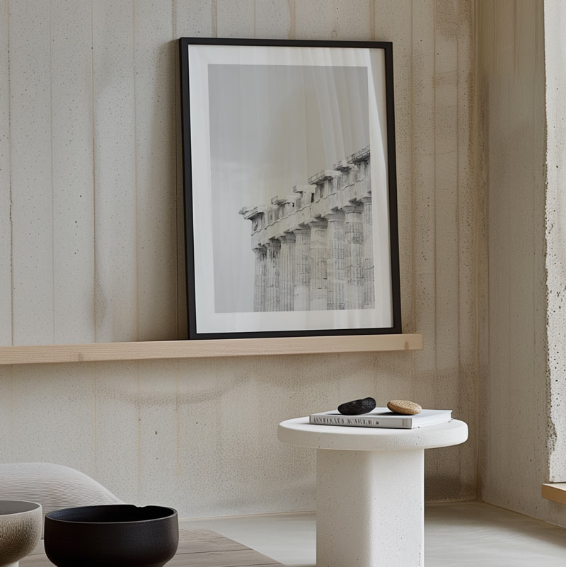 Framed artwork on a wooden shelf with minimal decor in a room.