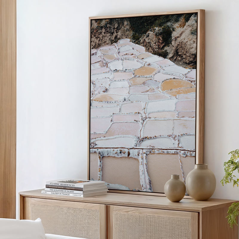 Framed abstract artwork on a wall above a wooden console table with decorative items.
