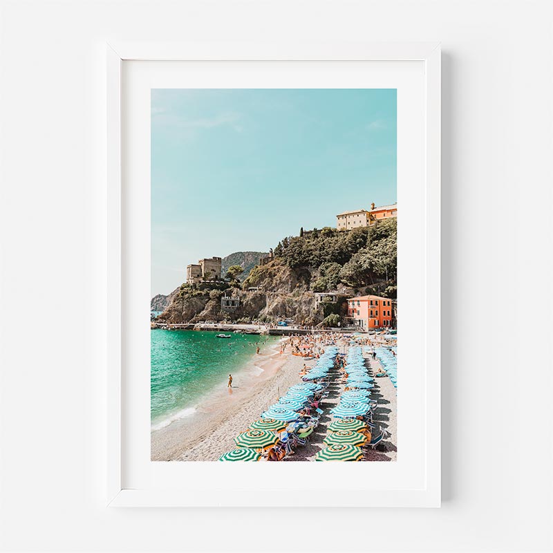 Framed photograph of a beach scene with colorful umbrellas and a clear blue sky.