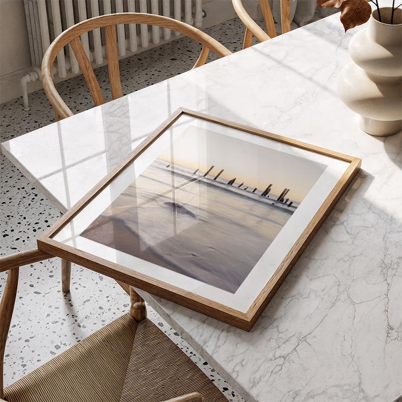 Framed artwork on a marble table with chairs in a room setting