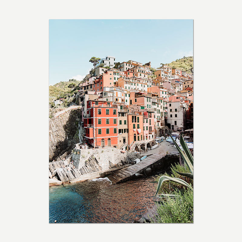 Colorful coastal town with buildings on a hillside overlooking the sea.
