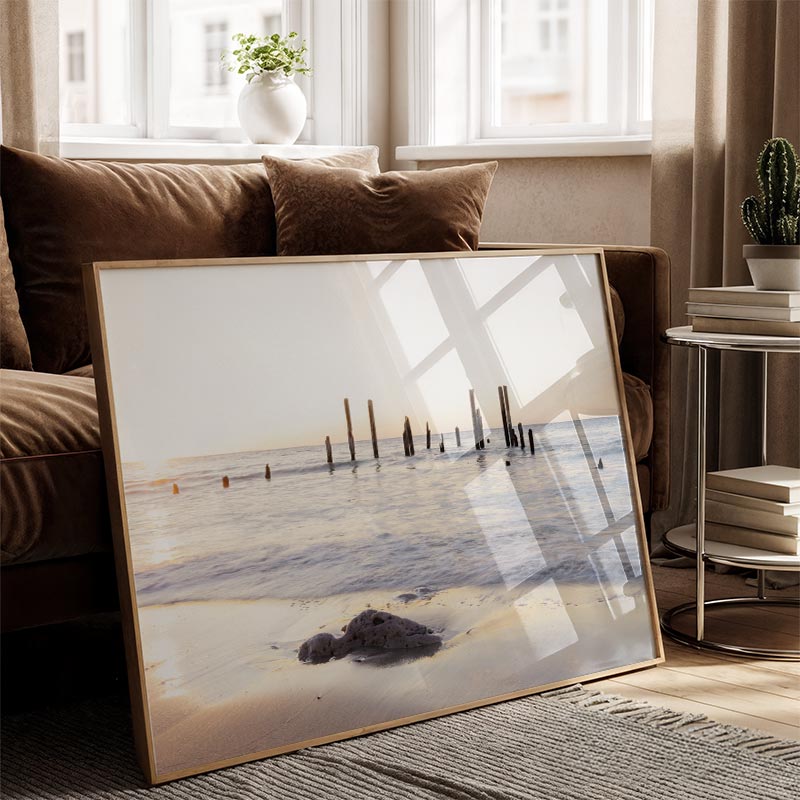Framed beach scene art piece in a living room setting