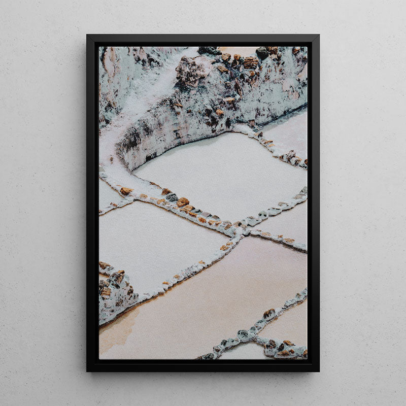 Framed photograph of a textured surface with geometric patterns on a white wall.