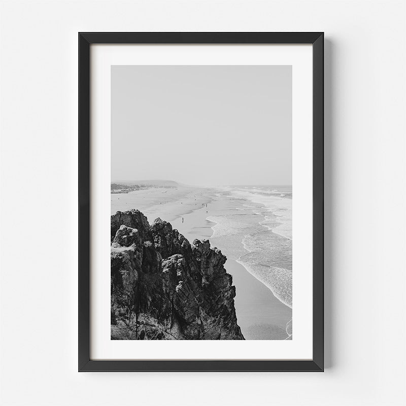 Framed black and white photograph of a coastal landscape with cliffs and beach.