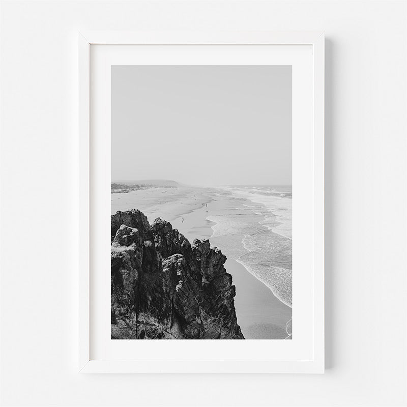 Framed black and white print of a coastal scene with cliffs and beach.