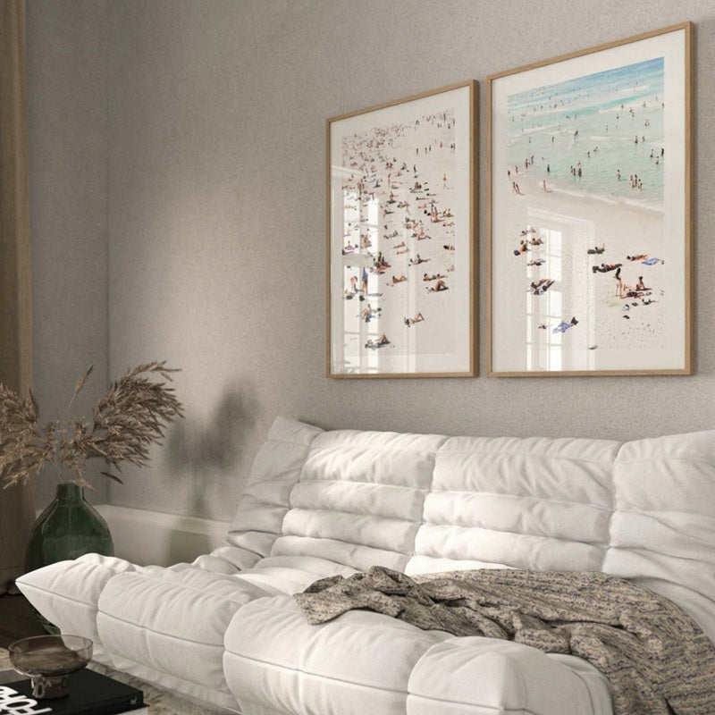 White sofa with two framed artworks on a gray wall