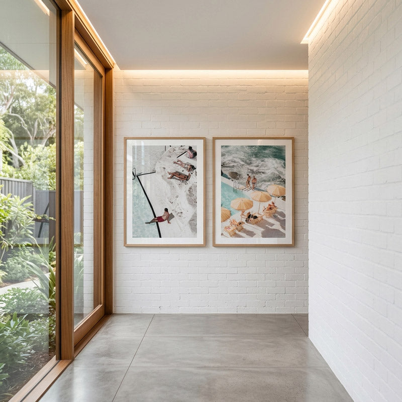 Modern interior with framed beach scenes on a white brick wall.