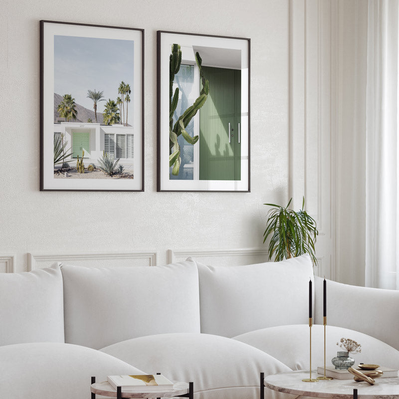 Living room with white sofa, decorative pillows, and framed artwork on the wall.