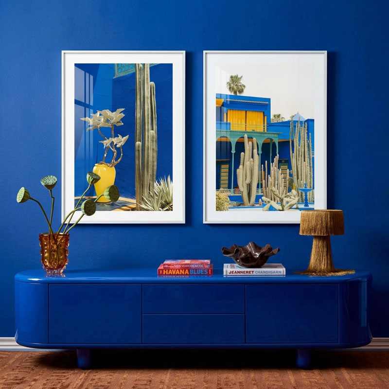 Blue living room with a console table, decorative items, and two framed artworks on a blue wall.