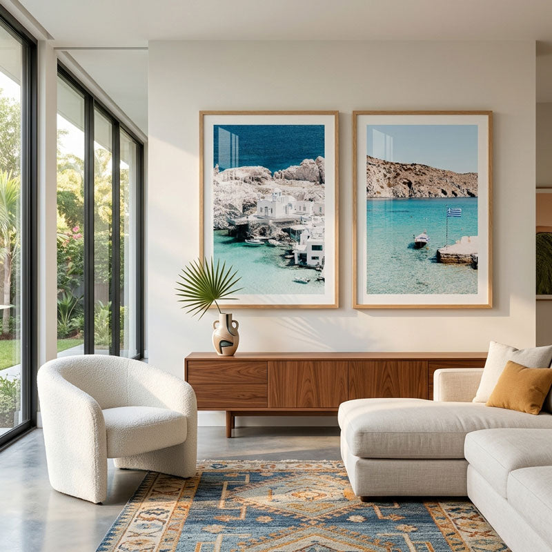 Modern living room with a sofa, armchair, and framed beach photos.