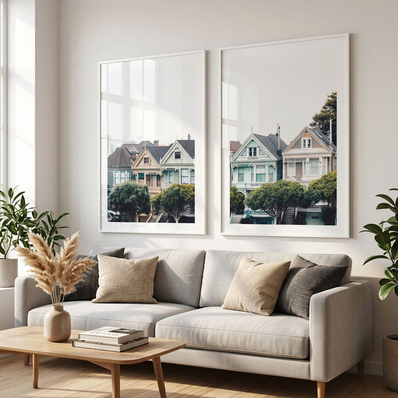 Living room with a gray sofa, wooden coffee table, and two framed pictures of houses on the wall.