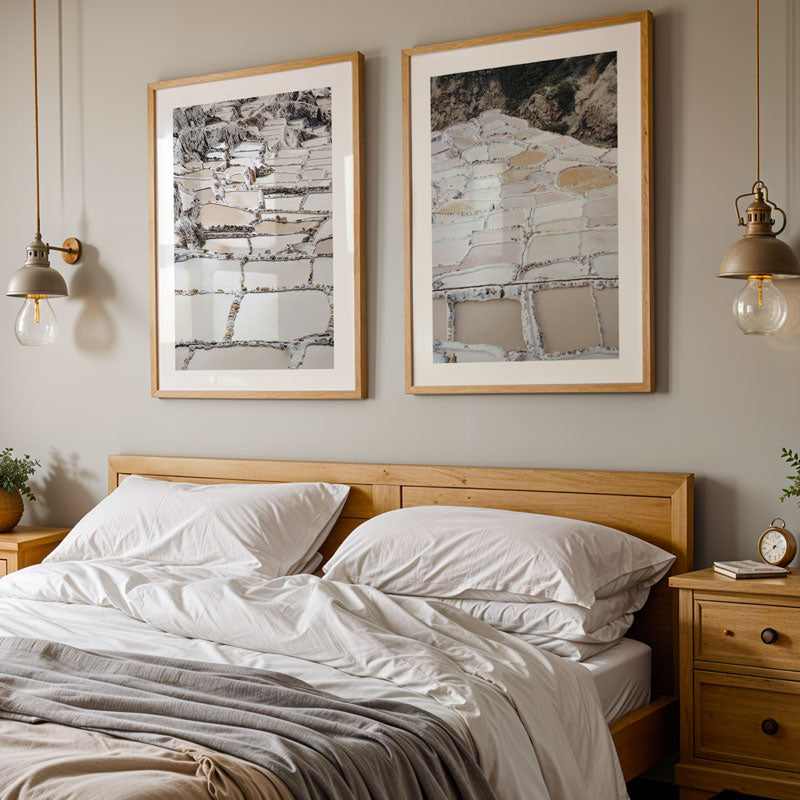 Bedroom with wooden headboard, white bedding, and framed artwork on the wall.