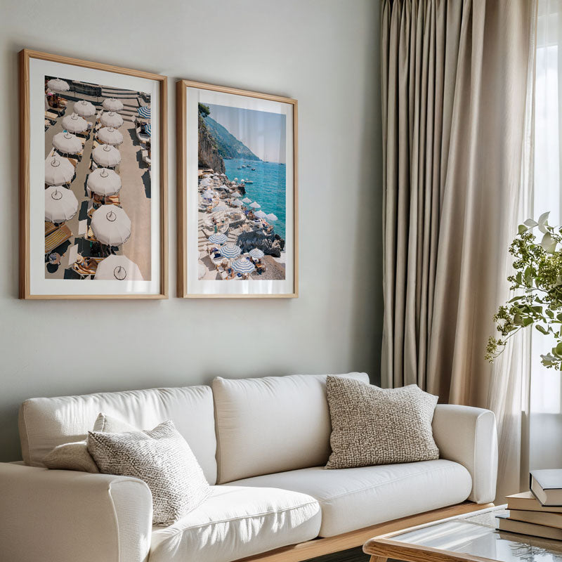 Living room with a white sofa, framed artwork on the wall, and a plant.