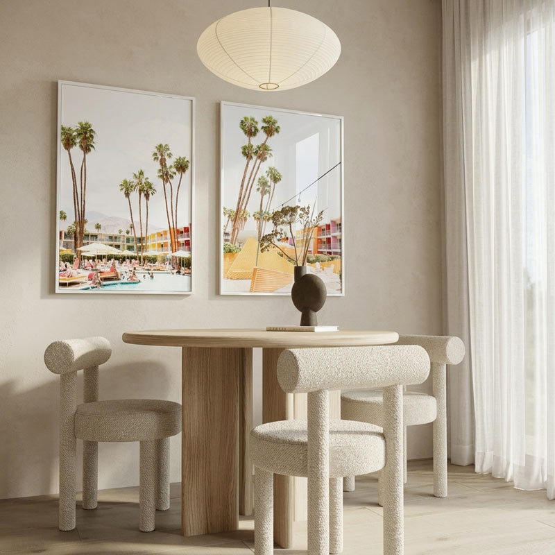 Dining room with wooden table and chairs, framed palm tree pictures on the wall.