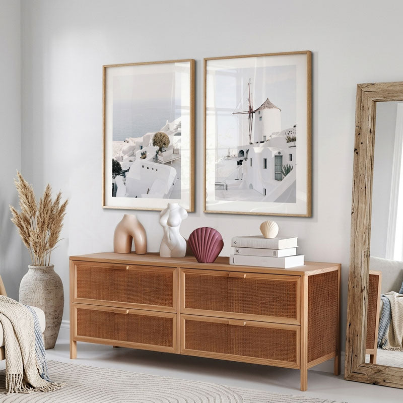 Wooden dresser with decorative items in a room with framed art and a mirror.