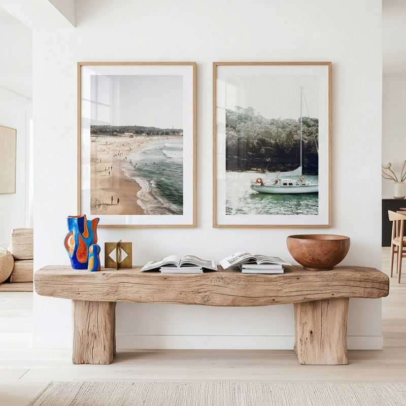 Living room with wooden bench, decorative vase, and framed artwork on a white wall.