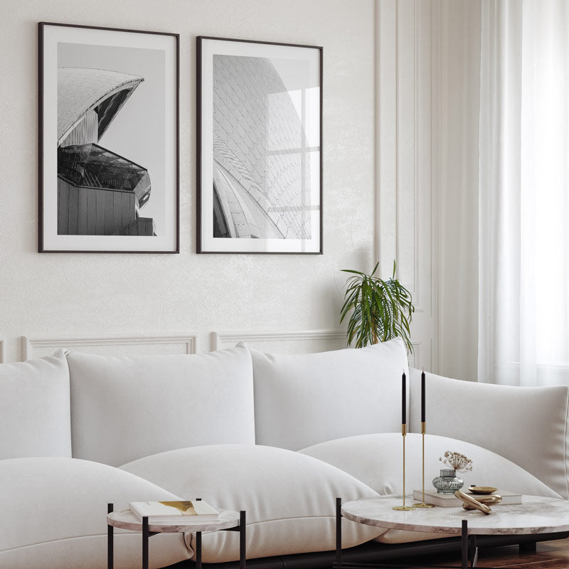 Modern living room with white sofa, marble coffee table, and framed abstract art on wall.