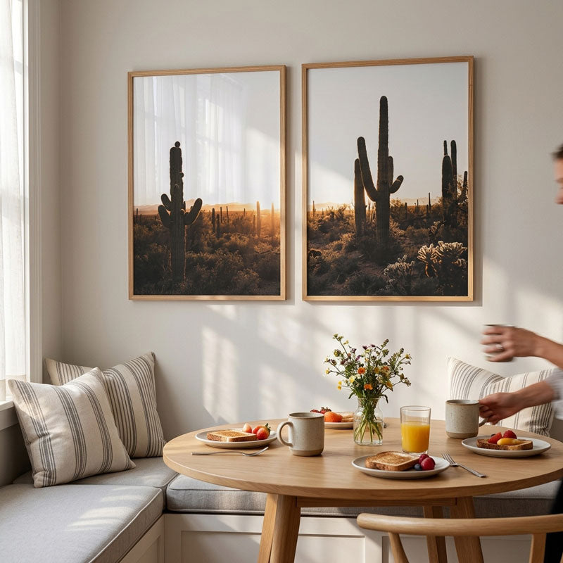 Dining room with a table set for breakfast, cactus wall art, and a person sitting.
