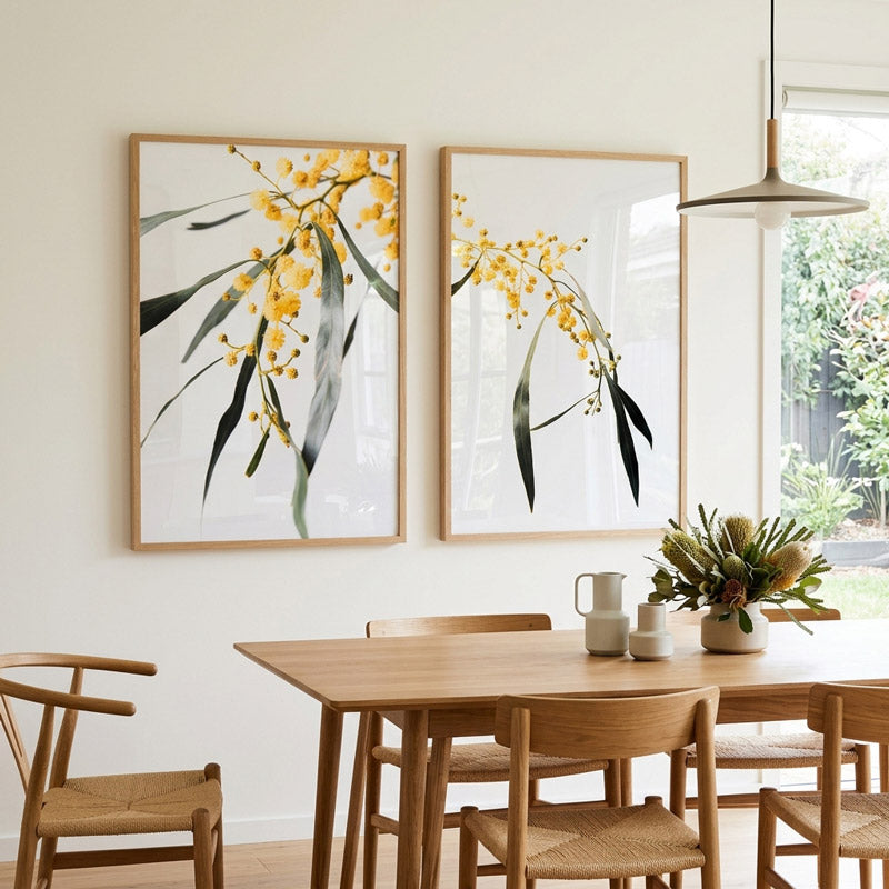 Dining room with wooden table and chairs, featuring two framed botanical prints on the wall.