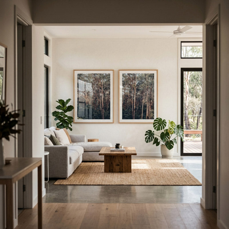 Modern living room with a gray sofa, wooden coffee table, and large windows.