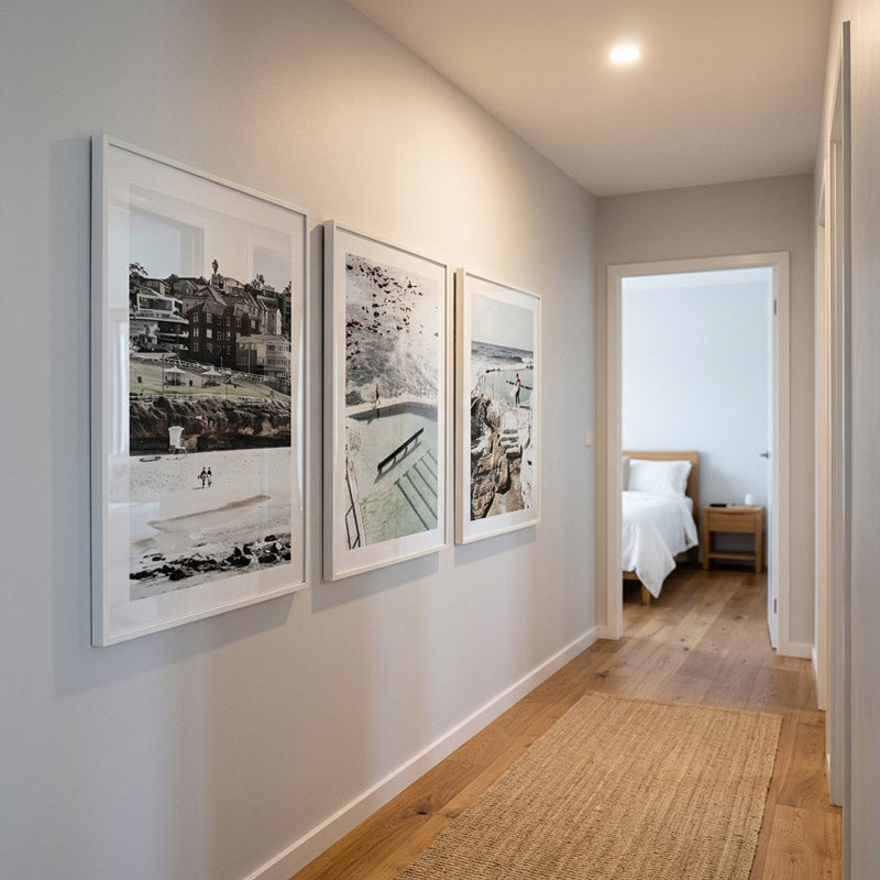 Framed artworks on a wall with a bedroom in the background
