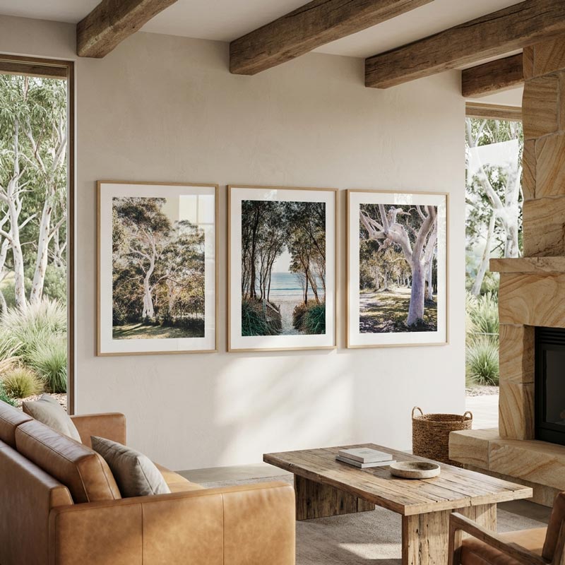 Living room with brown leather sofa, wooden coffee table, and three framed landscape pictures on the wall.