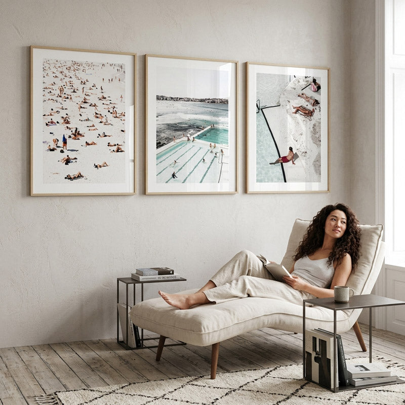 Woman reading a book on a chaise lounge in a stylish living room with wall art.