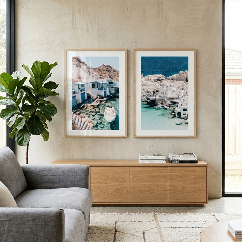 Living room with two framed artworks on the wall, a gray sofa, and a wooden cabinet.