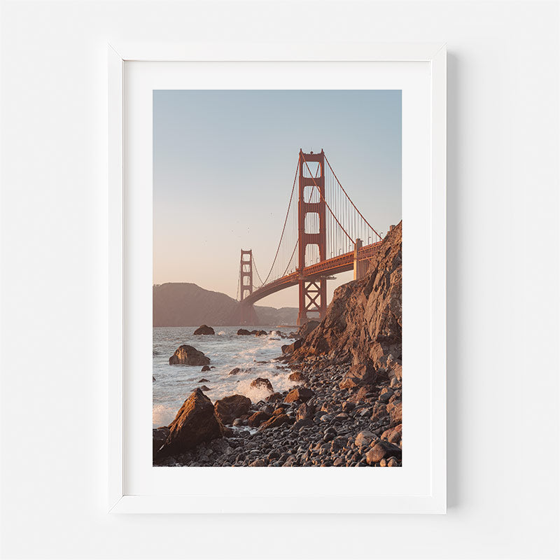 Framed photograph of the Golden Gate Bridge from a rocky beach.