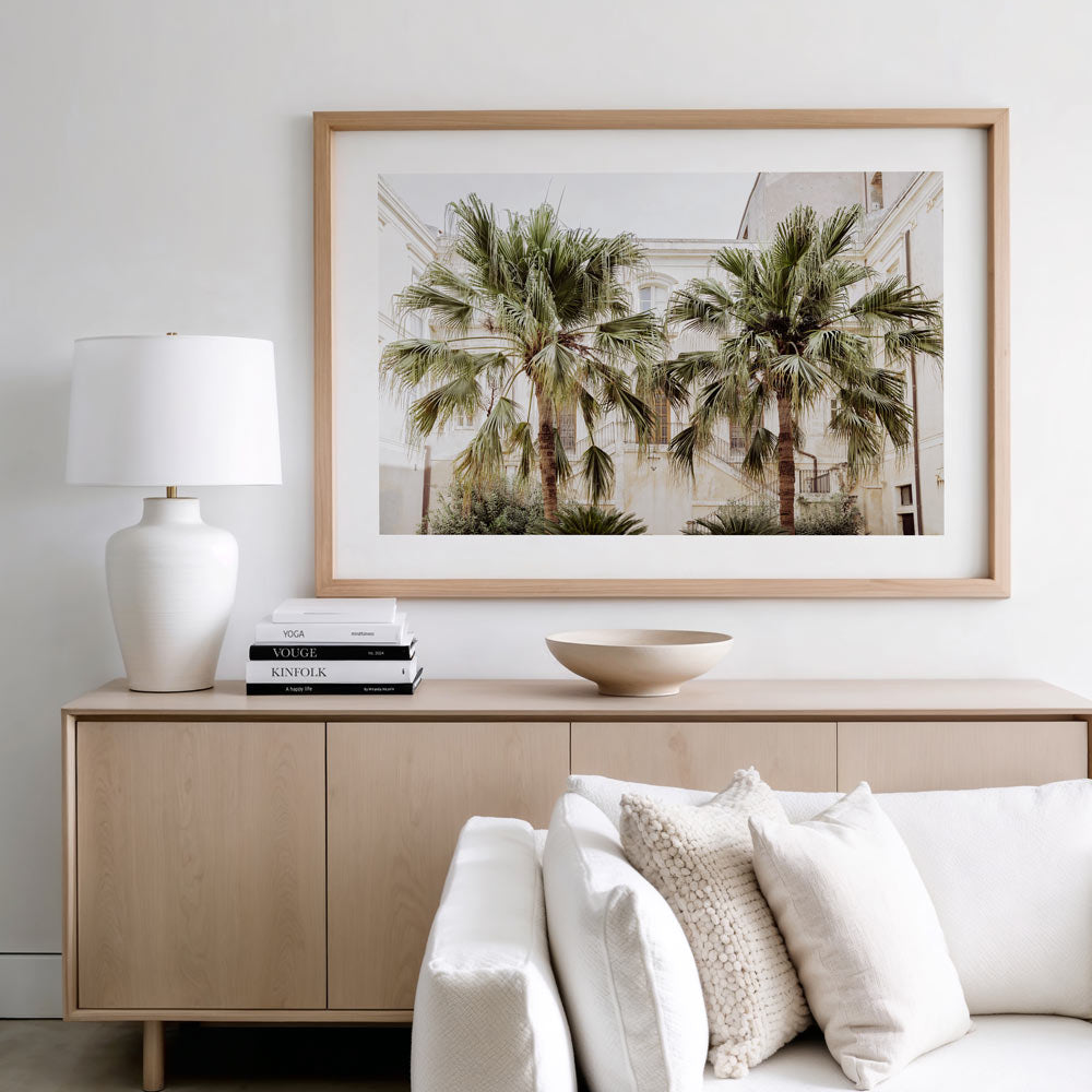 Unique coastal wall art print featuring twin palm trees in a sunlit courtyard of historic buildings in Syracuse, Sicily – muted neutral tones and Mediterranean textures perfect for beach wall art and framed coastal décor.
