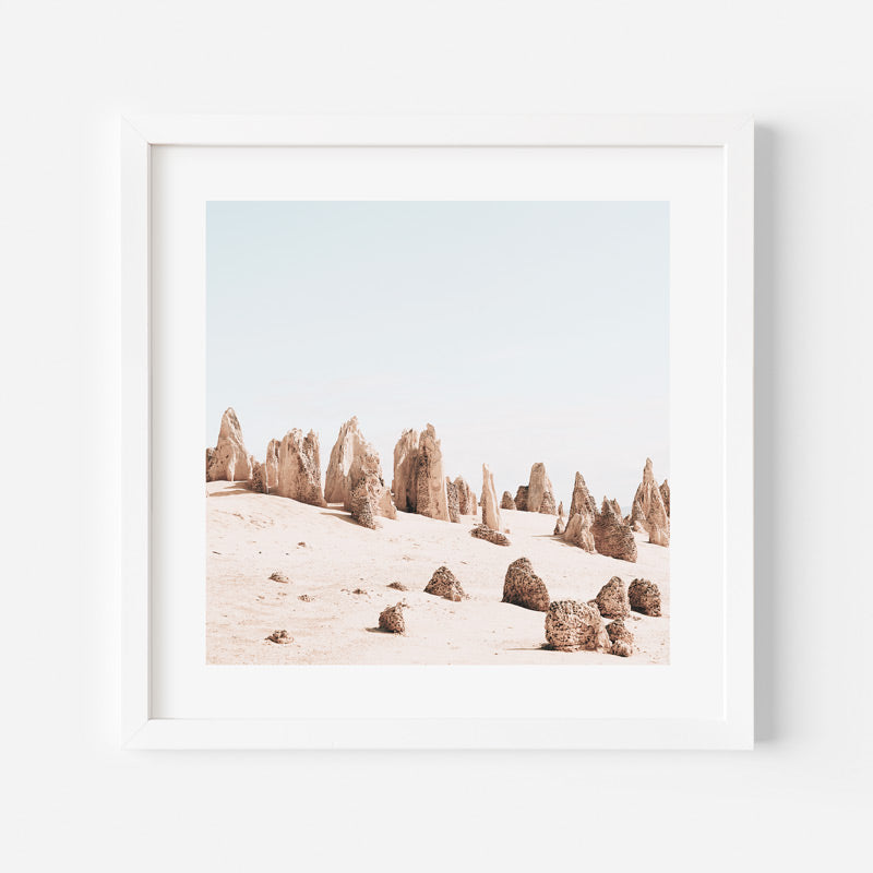 Framed artwork of desert landscape with rock formations on a white background