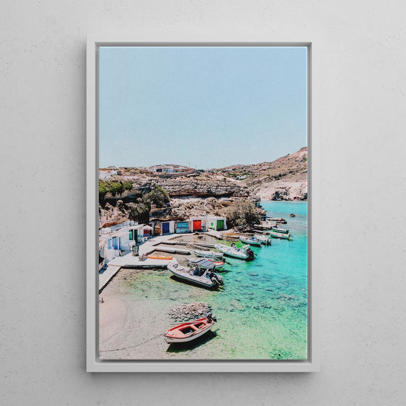 Framed photograph of a coastal scene with boats and a clear blue sky.
