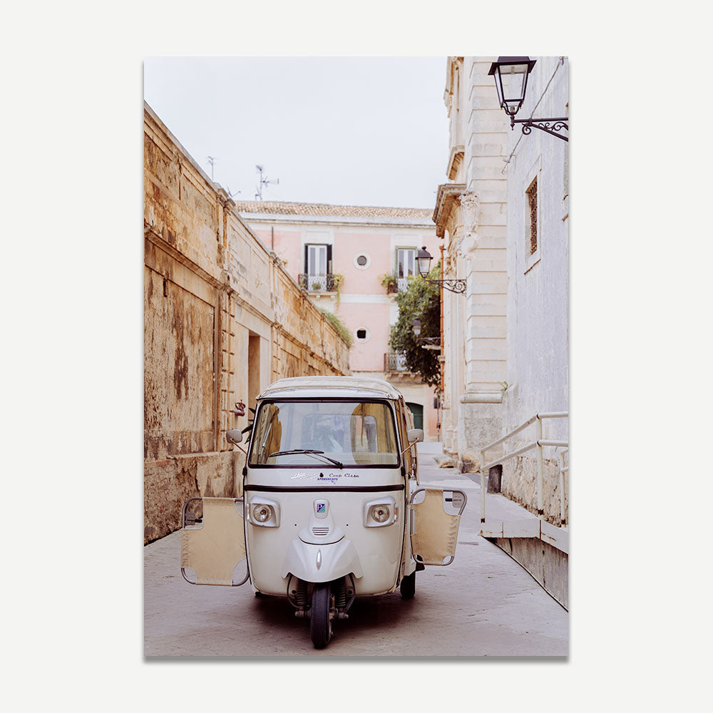 Tuk tuk vehicle parked on a quiet street in Syracuse, Sicily, captured in muted neutral tones – framed coastal wall art perfect for travel-inspired beach decor.