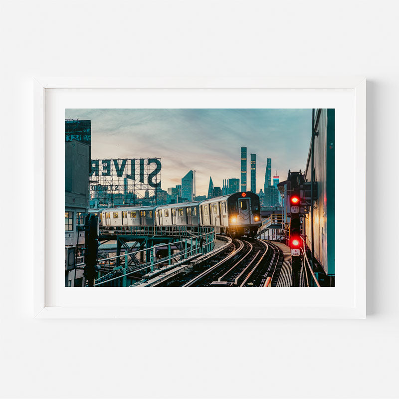 Cityscape with a train on tracks and 'Silver City' sign in the background