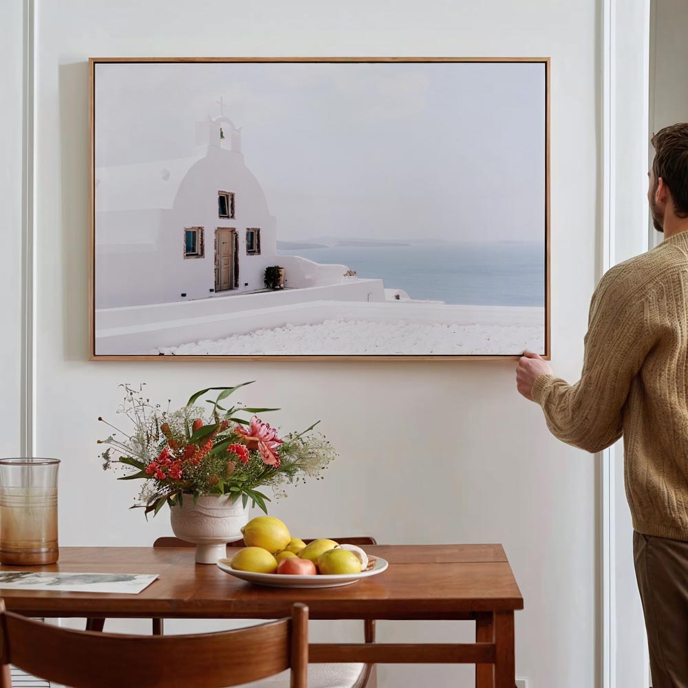 Tranquil moment captured in Oia, Santorini, featuring a whitewashed chapel against the beautiful backdrop of the village.
