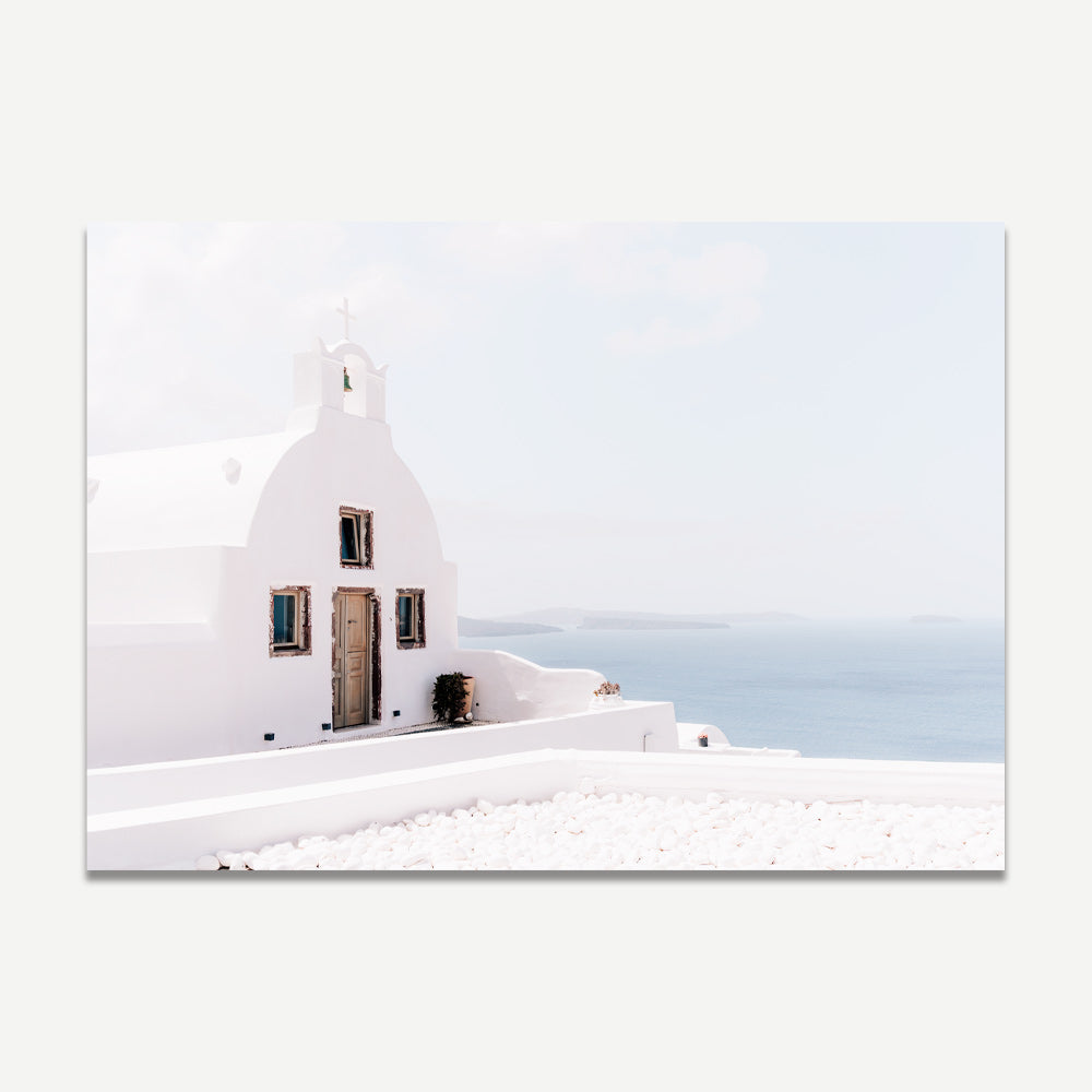 Elegant whitewashed chapel photographed in Oia, Santorini, showcasing the serene beauty of the island.