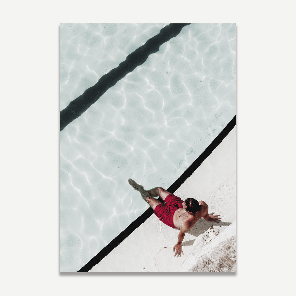 The print of a man in red shorts bathing on the edge of the pool at Bondi Icebergs pool
