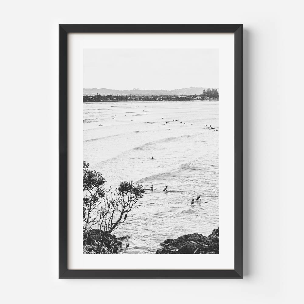 Surfers in the ocean captured in black and white at THE PASS, BYRON BAY. Perfect wall art for a modern art gallery from Oblongshop