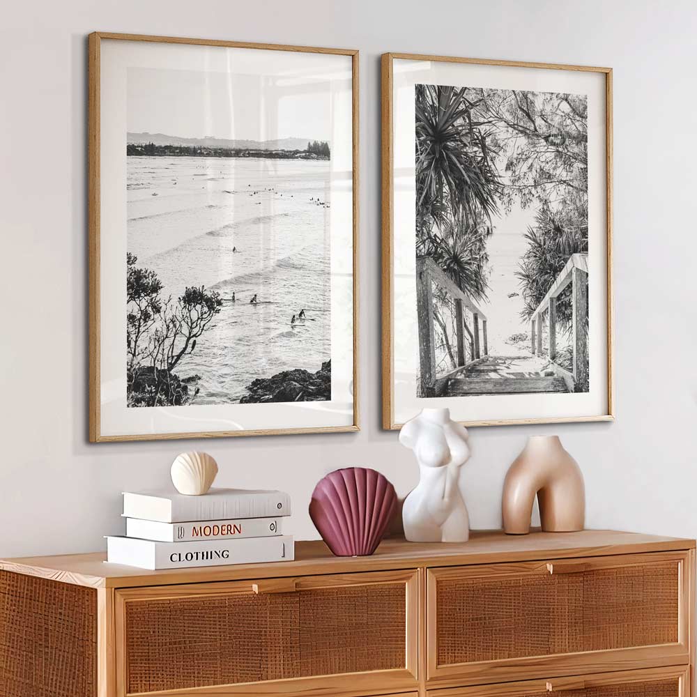 Surfers in the ocean: A captivating black and white photograph capturing surfers riding waves at THE PASS, BYRON BAY. Perfect wall art for any space.