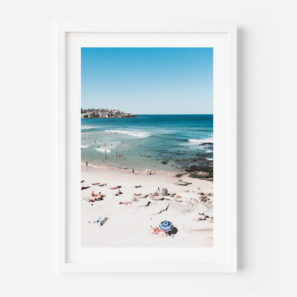 A white framed photo capturing people swimming on Bondi Beach - a serene and vibrant wall art for your home or office decor.