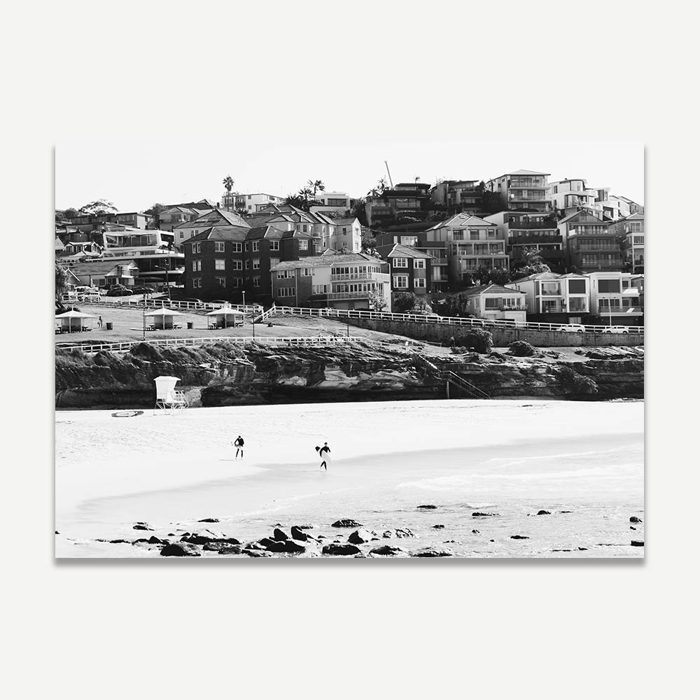 A black and white photograph of Bronte Beach with beachgoers and buildings in the background.