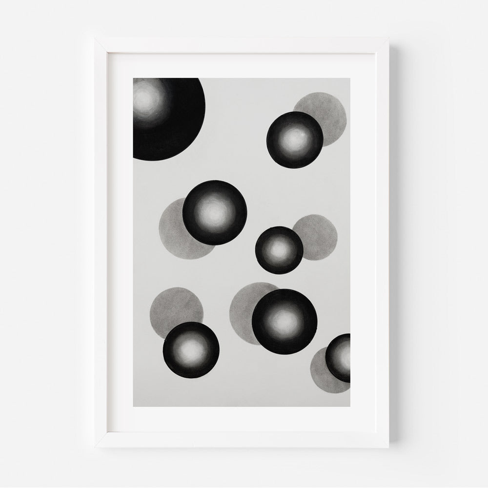A black and white photograph of an abstract artwork featuring overlapping circles of various shades on a white background, framed in a simple white frame.