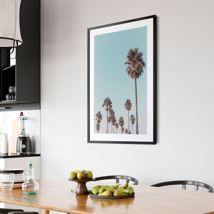 California Coastal Print: Relaxing view of palm trees against a blue sky in California. Perfect for wall art. Available as canvas or framed print.