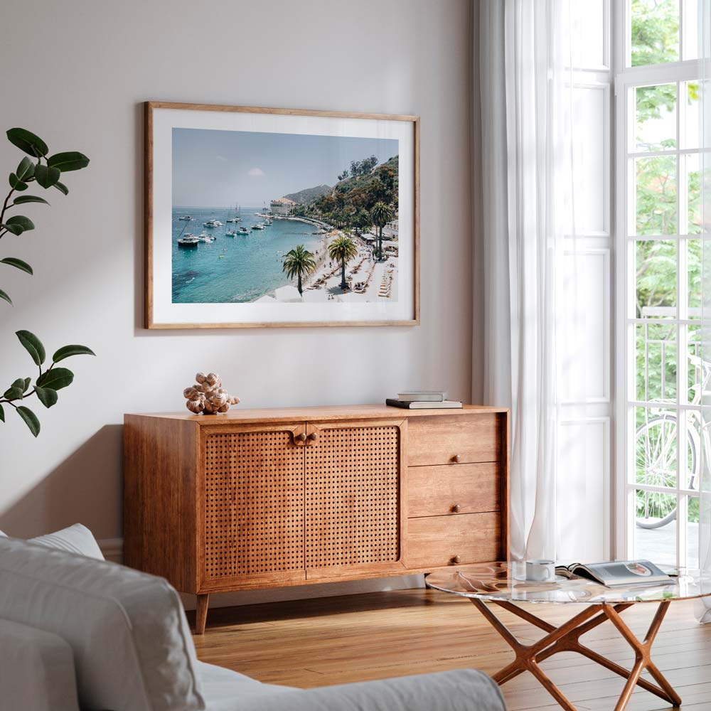 Wall art featuring a white framed photo of a beach with boats and palm trees. Real photography from Santa Catalina Island, California by Oblongshop.