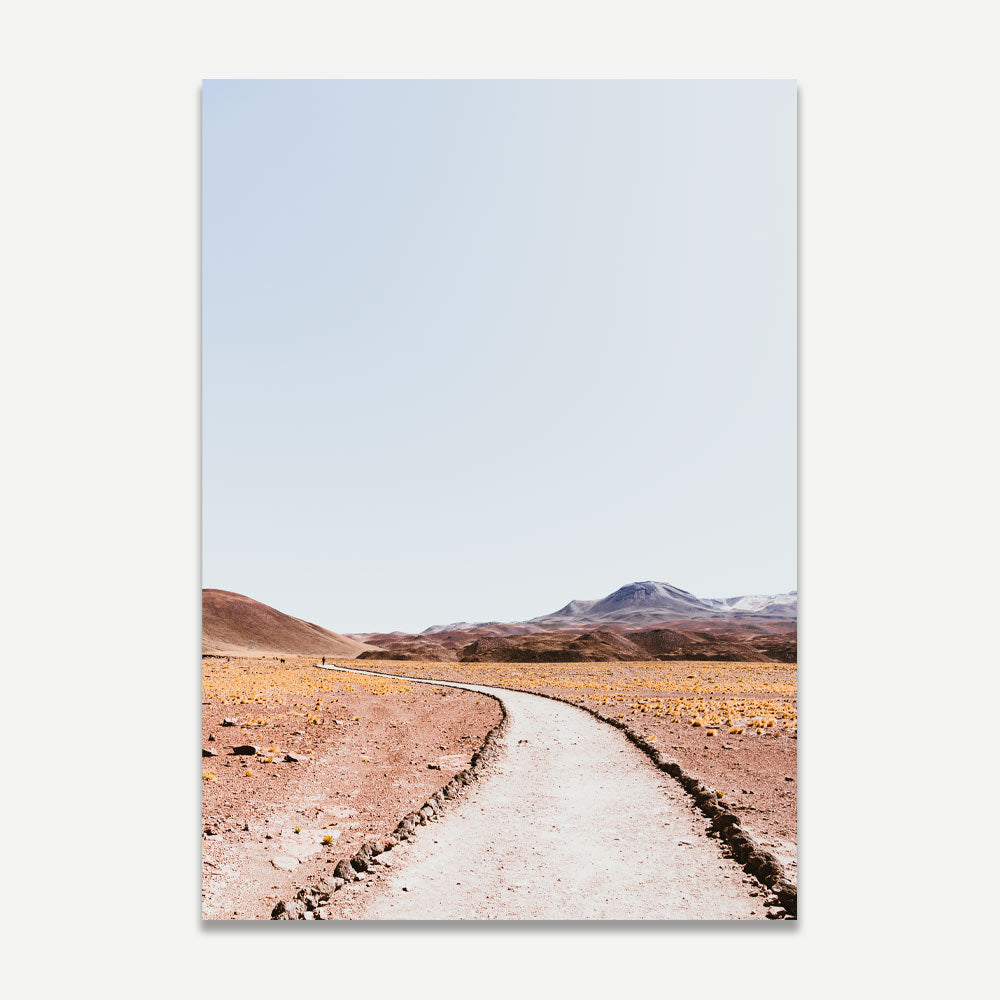 A landscape photograph titled 'Rocky Road II', featuring a dirt road extending into a desert landscape with mountains in the background.