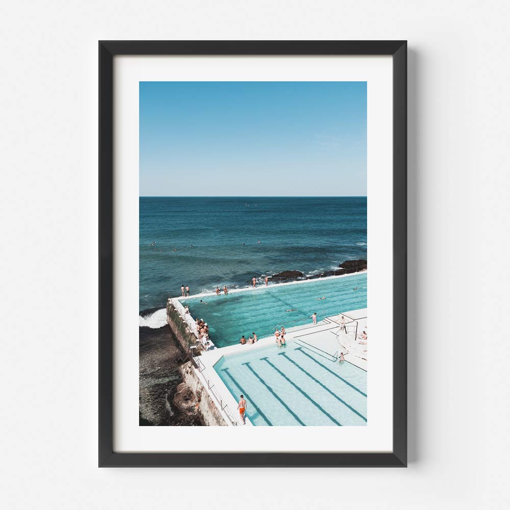 Experience tranquility with Oblongshop's framed art: a black-framed photo of Bondi Icebergs bathers by the pool and ocean.